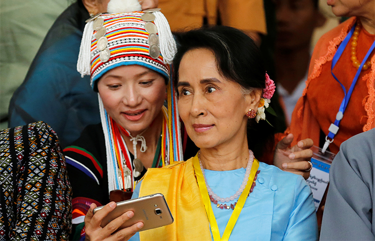 A woman takes a selfie with Myanmar State Counsellor Aung San Suu Kyi in Myanmar in May. Journalists say conditions for press freedom have not significantly improved under her rule. (Reuters/Soe Zeya Tun)