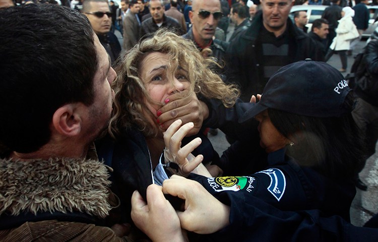 In this file photograph, police detain a protester during a March 6, 2014, demonstration in Algiers against Algerian President Abdulaziz Bouteflika's decision to run for a fourth term. (Reuters/Ramzi Boudina)