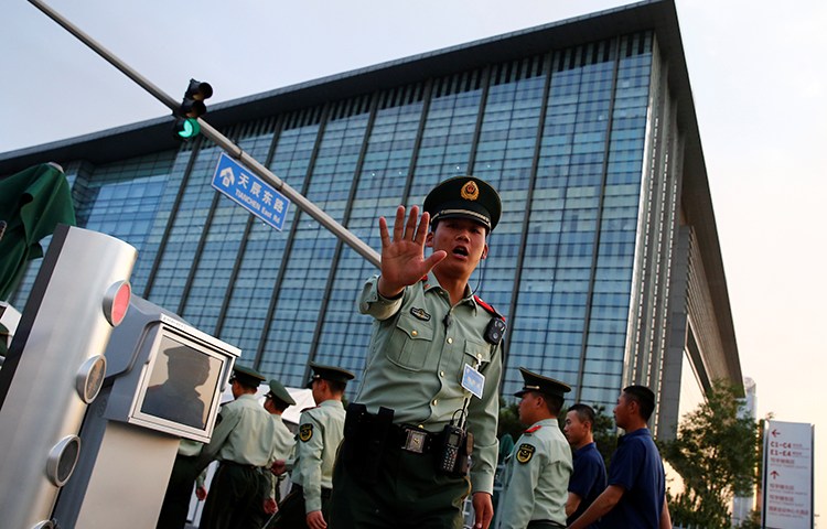 A policeman tells a photographer not take pictures, in Beijing, May 12, 2017. (Reuters/Thomas Peter)