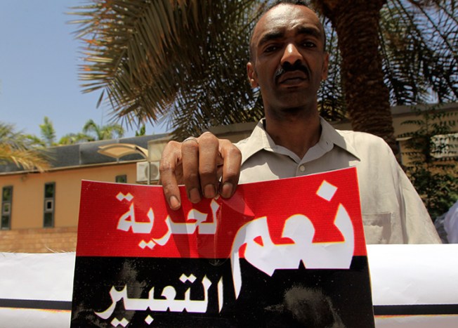 A Sudanese journalist in Khartoum holds a sign reading "Yes to freedom of expression" in this file photo from June 2012. (Reuters/Mohamed Nureldin Abdallah)