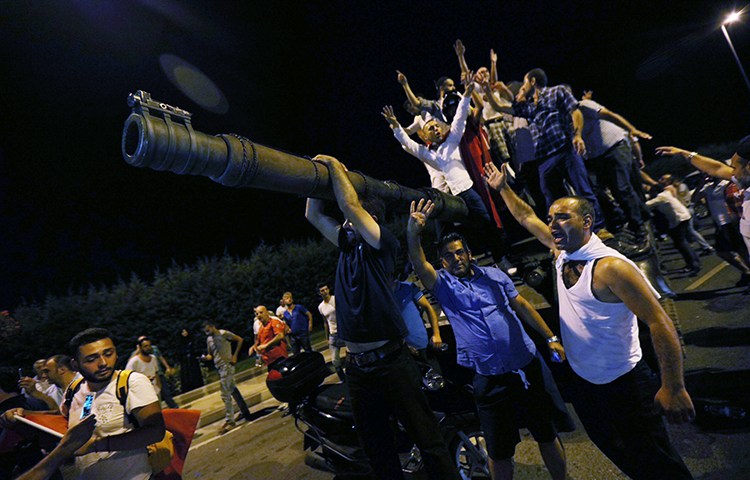 People stand atop a military tank at Istanbul's Ataturk Airport, in the early hours of July 16, 2016. (Reuters/Huseyin Aldemir)