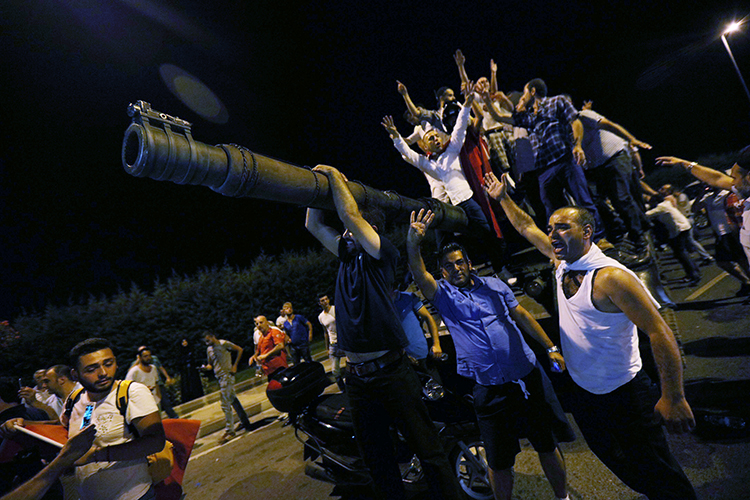 People stand atop a military tank at Istanbul's Ataturk Airport, in the early hours of July 16, 2016. (Reuters/Huseyin Aldemir)