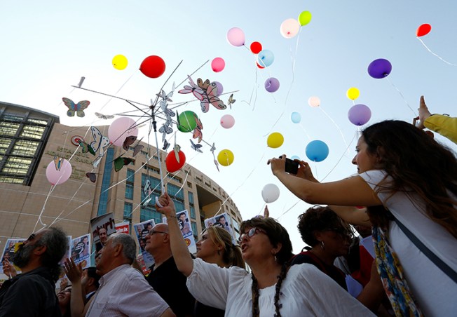 Journalists and press freedom advocates release balloons in front of the courthouse in Istanbul where 17 journalists and board members from Cumhuriyet newspaper were standing trial, July 24, 2017. (Reuters/Murad Sezer)