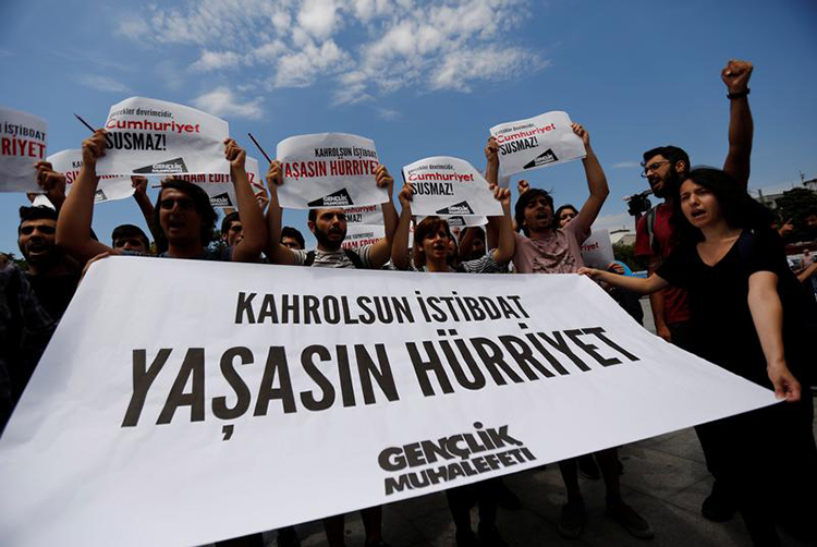 Press freedom advocates chant hold a banner saying "To hell with despotism, long live freedom" outside an Istanbul courthouse where journalists from Cumhuriyet newspaper stood trial, July 28, 2017. (Reuters/Murad Sezer)