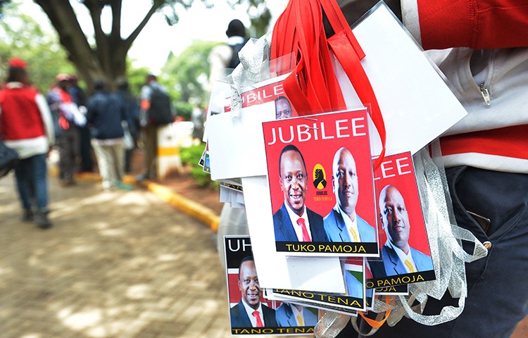 A vendor sells badges of Kenya's President Uhuru Kenyatta, left, and his deputy William Ruto in May. Kenya is seeking to restrict commentary on social media ahead of the August elections. (AFP/Simon Maina)