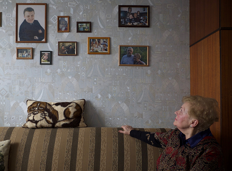 Lyudmila Sheremet, pictured looking at photos of her son in her Minsk apartment, says investigators have rarely provided her with updates into her son’s murder investigation. (Christopher Miller)