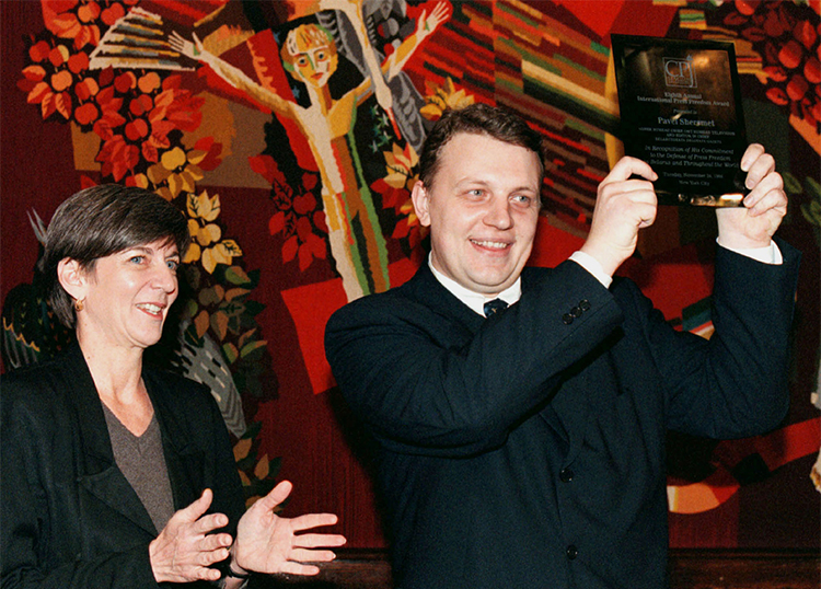 Pavel Sheremet, pictured with CPJ’s then-executive director Ann Cooper, lifts his International Press Freedom Award during a ceremony in 1998. (Reuters/Vasily Fedosenko)