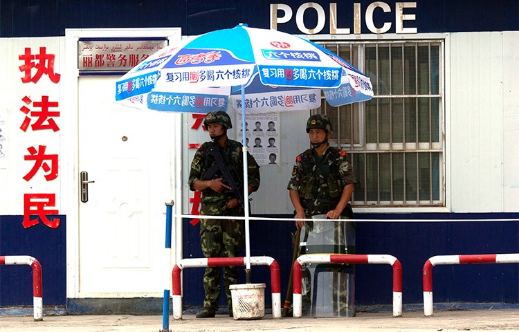 Chinese paramilitary policemen guard a checkpoint in China's Xinjiang province. Authorities briefly detained a Canadian journalist in the region who was interviewing residents about the Uighurs' security situation. (AP/Ng Han Guan, File)