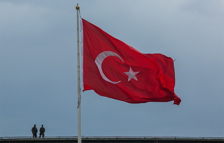 Soldiers stand near a Turkish flag in Istanbul in May 2017. Photojournalist Çağdaş Erdoğan is charged with terrorism for taking a photo of a National Intelligence Building. (AFP/Gurcan Ozturk)