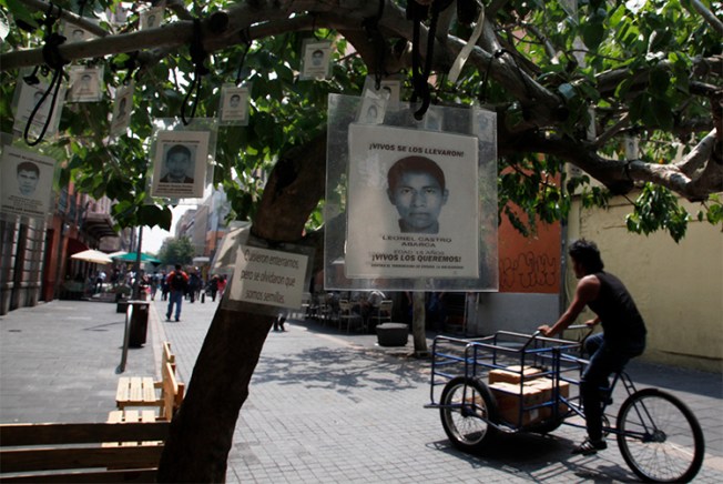 Images of 43 missing students from Guerrero state hang from a tree in Mexico City . Journalists reporting on violence in the state, and on the case of the students, face threats and violence. (AP/Marcos Ugarte)