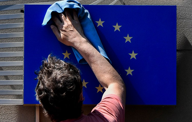 A worker cleans a EU flag in Berlin on May 19, 2017. The EU parliament is due to vote on October 12 on a proposed review mechanism of surveillance tool exports. (AFP/John MacDougall)