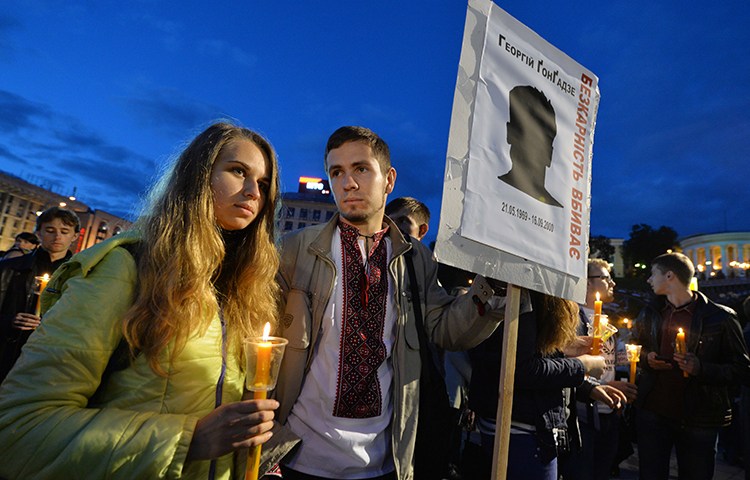 People hold signs saying 'Impunity kills' during a 2013 memorial in Kiev for murdered Ukrainian journalist Georgy Gongadze. The US decision to withdraw from UNESCO will make the world less safe for journalists. (AFP/Sergei Supinsky)