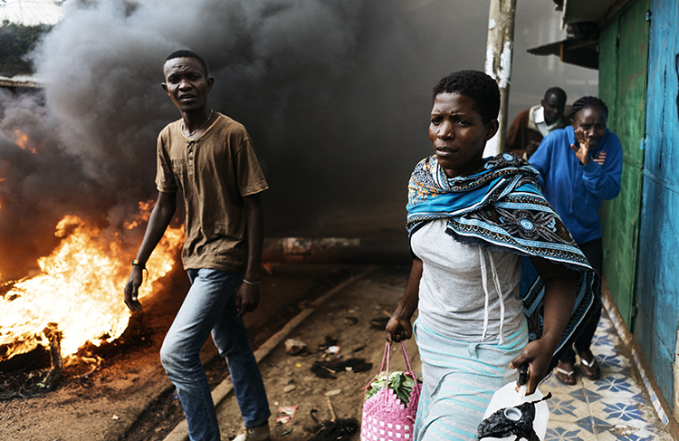 Residents pass a burning barricade in Kibera, Nairobi, on October 25, the day before presidential re-elections are held. Journalists covering the vote should take safety precautions. (AFP/Marco Longari)