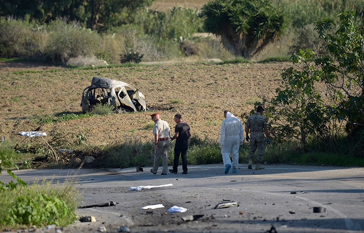 Police and forensic experts inspect the wreckage of a car bomb that killed journalist and blogger Daphne Caruana Galizia close to her home in Bidnija, Malta. (STR/AFP)