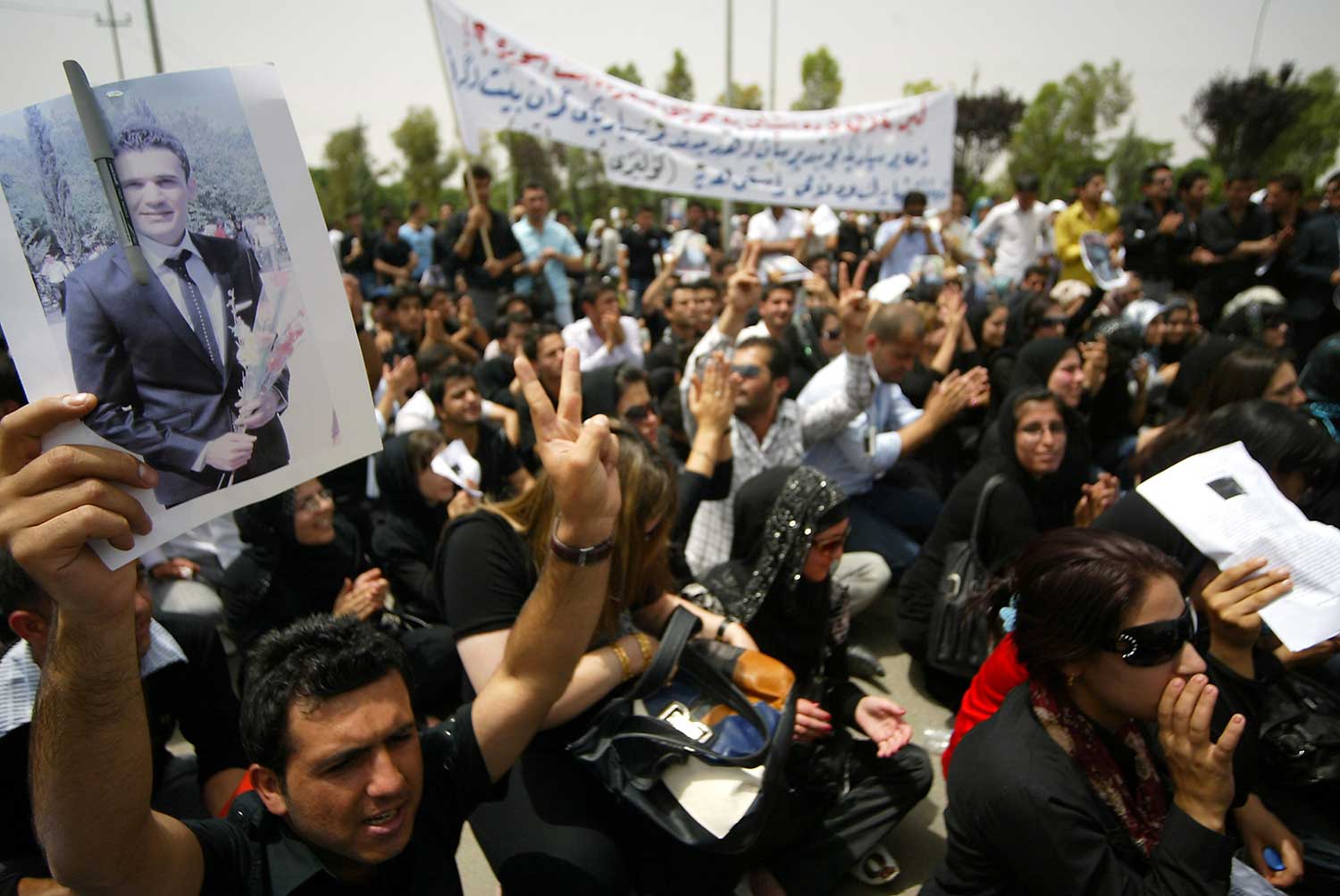 A Kurdish Muslim cleric on May 6, 2010, leads mourners in a prayer over Kurdish journalist and student Sardasht Osman who was kidnapped and killed that day in Erbil in the autonomous Kurdish region of Iraq. Seven years later, no one has been convicted of his murder. (AFP/Safin Hamed)