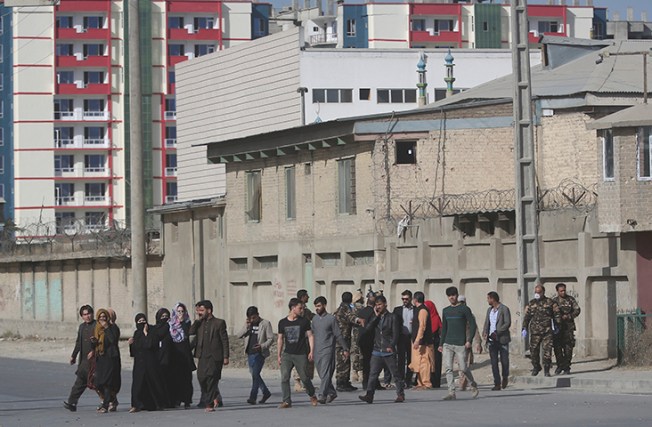 Security personnel evacuate employees of the Shamshad TV building after an attack in Kabul, Afghanistan, Tuesday, Nov. 7, 2017. (AP/Massoud Hossaini)