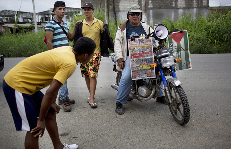 A vendor waits for customers while selling newspapers on his motorcycle, one week after an earthquake in Pedernales, Ecuador. A local journalist says years of self-censorship among the press led to 'timid' early reports of the disaster. (AP/Rodrigo Abd)