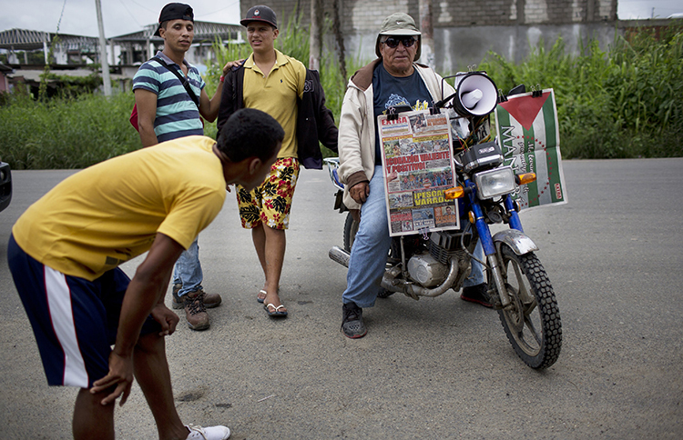 Un vendedor espera a los clientes mientras vende periódicos en su motocicleta, una semana después de un terremoto en Pedernales, Ecuador. Un periodista local dice que los años de autocensura entre la prensa provocaron informes preliminares "tímidos" sobre el desastre. (AP/Rodrigo Abd)