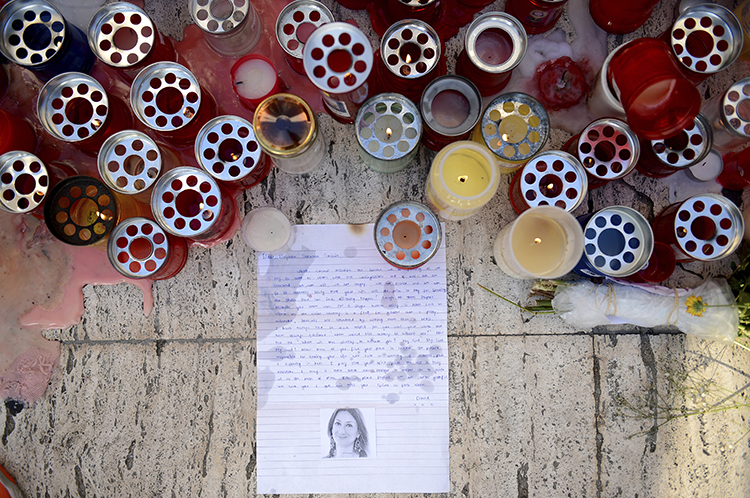 Candles and tributes are left for investigative journalist Daphne Caruana Galizia, who was murdered in Malta in October, (AP/ Rene Rossignaud)