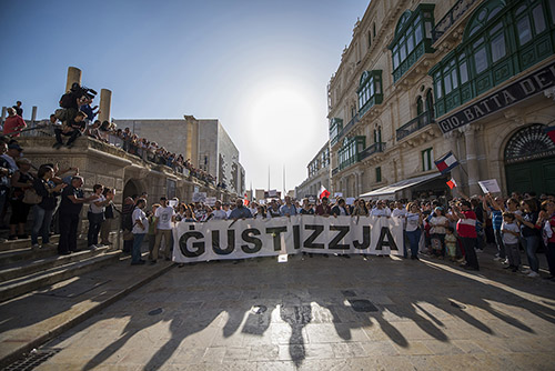 A rally in Malta to honor Daphne Caruana Galizia, an investigative journalist who was killed in October. The sign reads JUSTICE. (AP/Rene Rossignaud)