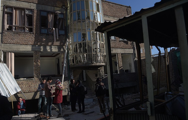 Residents gather at the site of a December 28 bombing in Kabul, Afghanistan, that killed at least one journalist. (AFP/Shah Marai)