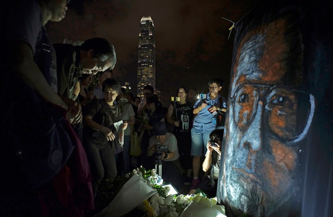 People pay tribute to Nobel laureate Liu Xiaobo in a park near Hong Kong's Victoria Habour in July 2017. The journalist died a few months after China finally agreed to release him on medical parole. (AP/Vincent Yu)