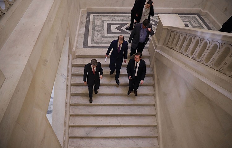 Senators talk together in the the Russell Senate Office Building after leaving a January 16 news conference about proposed reforms to FISA. The Senate has reauthorized Section 702 of the act in a move that could put journalists at risk. (Chip Somodevilla/Getty Images/AFP)