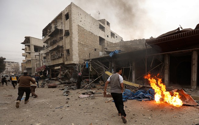 Civilians and members of the rescue organization, Syrian Civil Defense, run to the scene of an airstrike in Idlib province on January 3, 2018. An airstrike injured two Syrian journalists in the province on January 11. (AFP/Omar Haj Kadour)