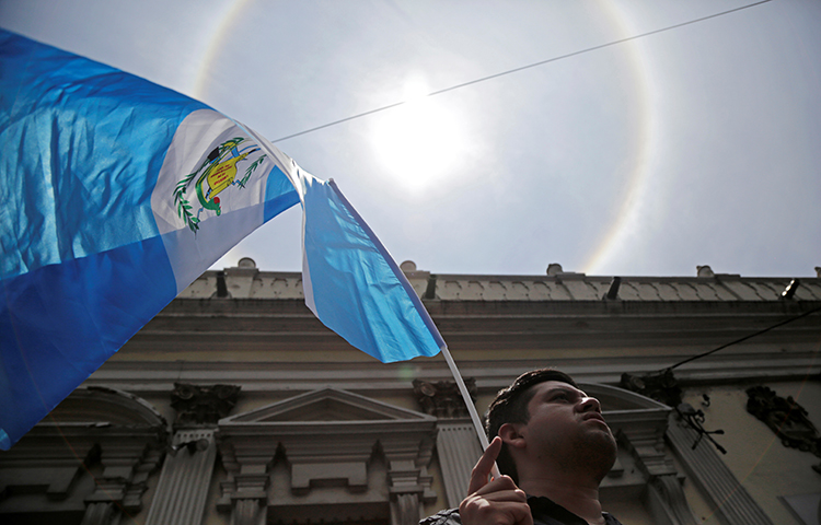 Um homem agita uma bandeira guatemalteca na Cidade da Guatemala, Guatemala, em 14 de setembro de 2017. (Reuters/Luis Echeverria)