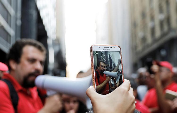 Se utiliza un teléfono celular para filmar una protesta a favor de los desamparados en São Paulo, en diciembre de 2017. En el período previo a los comicios de octubre, a la Policía se le ha encargado la tarea de combatir la difusión de las noticias falsas. (Reuters/Nacho Doce)