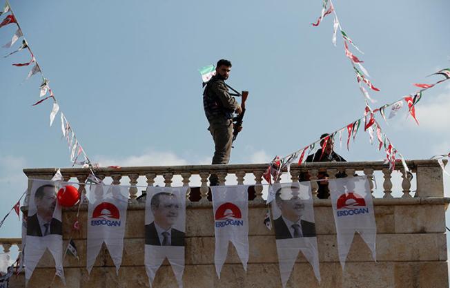 A Turkey-backed Free Syrian Army fighter stands guard on top of a building in Sawran village, Syria on February 1, 2018. Turkish authorities have arrested at least 300 people, including journalists, who have made critical comments about Turkey's incursion into Syria. (Reuters/Osman Orsal