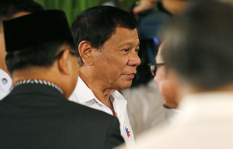 Philippine President Rodrigo Duterte, center, before he addresses Filipino Muslim leaders during a reception at the Presidential Palace to celebrate the end of the Holy Month of Ramadan in June 2017. Presidential spokesperson Harry Roque told local media the government decided to ban Rappler from covering official presidential events because Duterte had