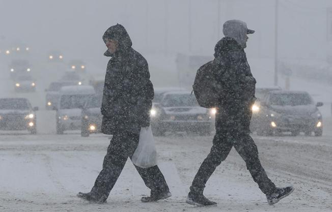 People cross a road during a heavy snowfall in Kiev, Ukraine in January 2018. Journalists at Media Holding Vesti remain blocked from their newsroom in central Kiev one week after dozens of law enforcement agents raided the office, editor-in-chief Oksana Omelchenko told CPJ. (Reuters/Valentyn Ogirenko)