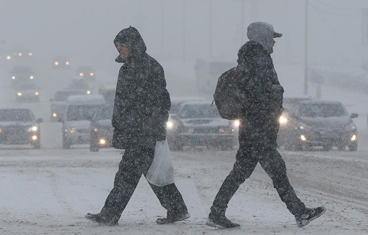 People cross a road during a heavy snowfall in Kiev, Ukraine in January 2018. Journalists at Media Holding Vesti remain blocked from their newsroom in central Kiev one week after dozens of law enforcement agents raided the office, editor-in-chief Oksana Omelchenko told CPJ. (Reuters/Valentyn Ogirenko)