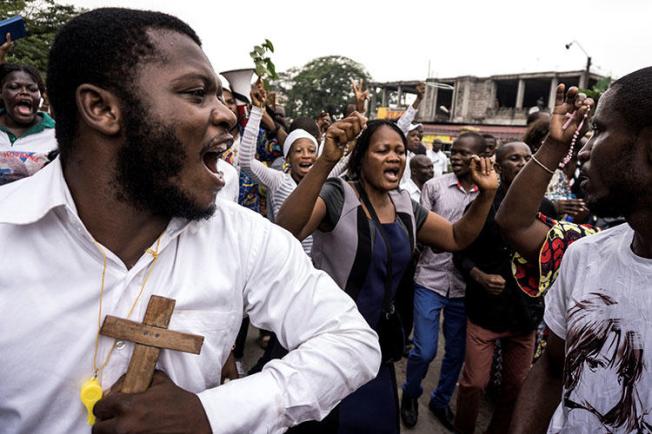 Catholics sing and dance during a December 31, 2017 demonstration to call for the President of the Democratic Republic of the Congo to step down. At least three journalists covering the rallies in Kinshasa say police harassed them. (AFP/John Wessels)