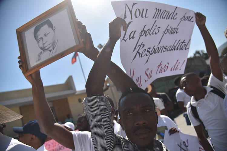 Haitian reporters and others march through the streets of Port-au-Prince on March 28, asking for information about missing freelance photojournalist Vladimir Legagneur. (AFP)