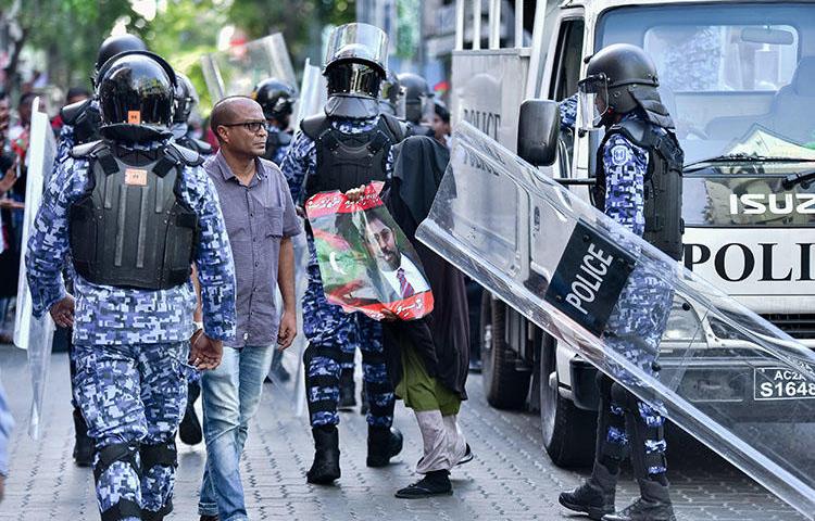 Maldivian police pictured at a protest in the capital, Malé, on March 2. Three Raajje TV journalists are detained over their coverage of anti-government protests held on March 16. (AFP/Ahmed Shurau)