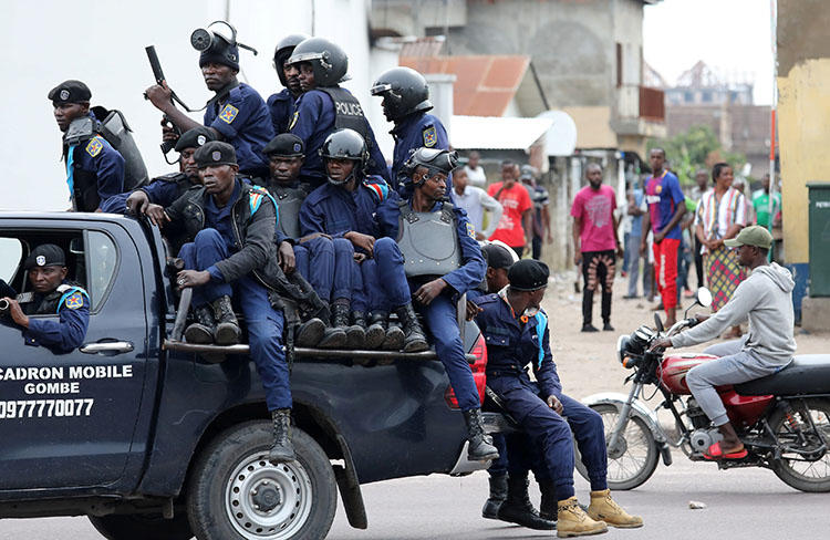 Police sit in a vehicle in front of Notre Dame Cathedral in Kinshasa, on February 25, 2018. Amid protests called by the Catholic Church, the DRC Telecommunications Ministry repeatedly orders internet and SMS shutdowns. (Reuters/Goran Tomasevic)