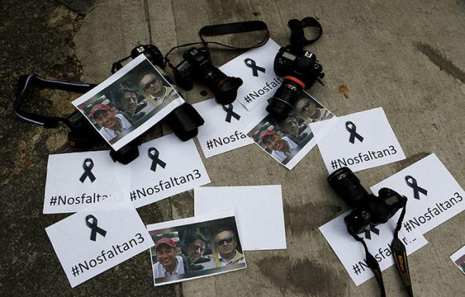 Colombian photographers leave the cameras on the floor in front of the Ecuadorean embassy in Bogota, Colombia, on April 16, 2018, to protest against the murder of journalist Javier Ortega, photographer Paul Rivas and their driver Efrain Segarra, (Reuters/Jaime Saldarriaga)