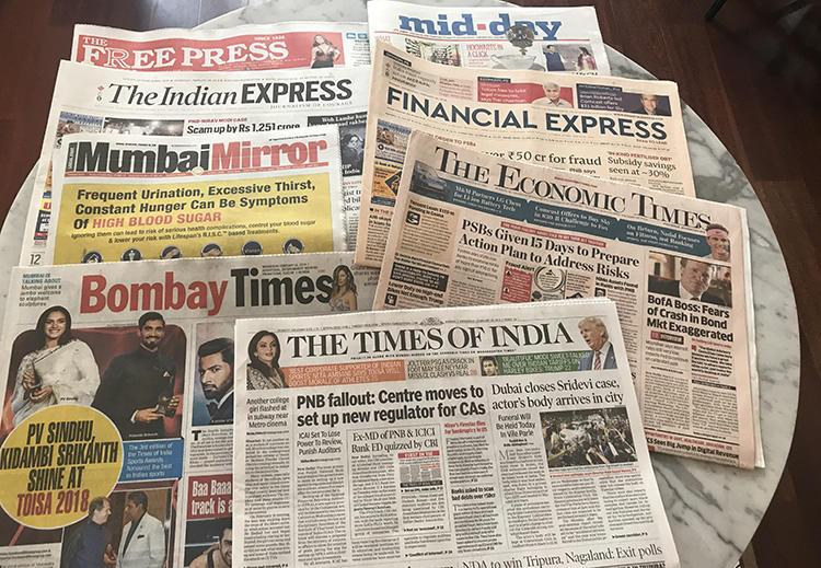 Copies of Indian newspapers are spread across a desk during a CPJ visit to the country in early 2018. (CPJ/Aliya Iftikhar)