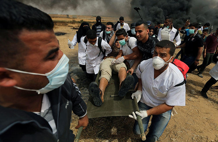 A wounded Palestinian is evacuated during clashes with Israeli troops at anti-Israel protests in the southern Gaza Strip on April 20, 2018. (Reuters/Ibraheem Abu Mustafa)