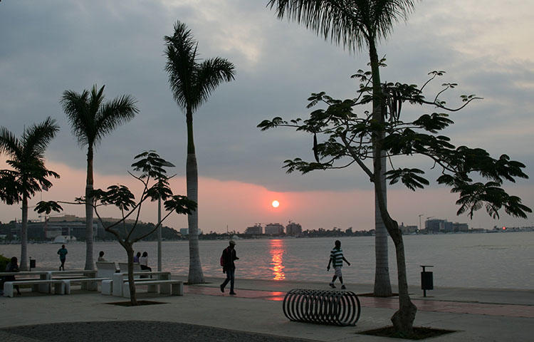 Locals walk along the beach during sunset in the capital Luanda, Angola in June 2016. CPJ today condemned a decision by Angolan authorities to continue the trial of journalists Rafael Marques de Morais, who runs the anti-corruption news website Maka Angola, and Mariano Bras Lourenco, a correspondent for the newspaper O Crime, behind closed doors instead of in open court. (Reuters/Ed Cropley)