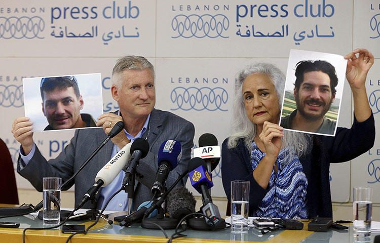 Marc and Debra Tice, the parents of Austin Tice, who went missing in Syria in 2012, hold up photos of him during a press conference at the Press Club in Beirut, Lebanon, on July 20, 2017. (AP/Bilal Hussein)