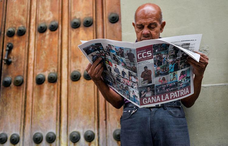 Em Caracas, um homem lê um jornal que alude à vitória do presidente reeleito Nicolas Maduro na eleição presidencial venezuelana de 21 de maio de 2018. O órgão regulador nacional de telecomunicações da Venezuela abriu uma investigação, em 22 de maio, sobre o conteúdo publicado no site do El Nacional, o maior jornal diário independente do país. (Luis Robayo/AFP)