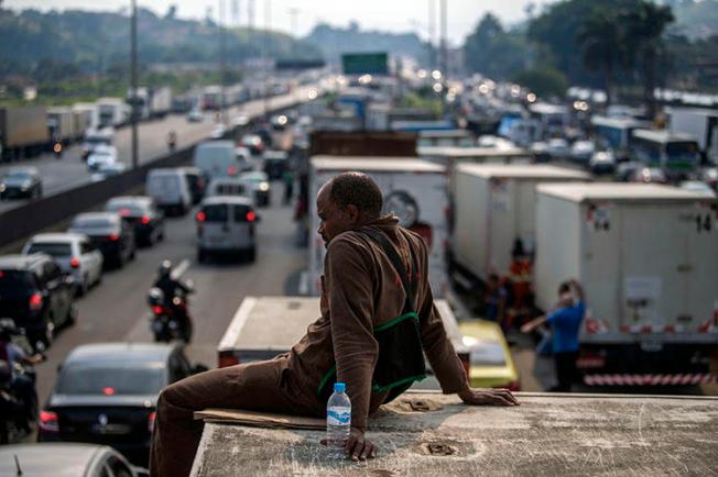 Brazilian truck drivers partially block a road during a nationwide strike to protest rising fuel costs in Rio de Janeiro, Brazil, on May 25, 2018. A radio host in northeastern Brazil has been subject to a series of threats in the first four months of 2018. (Mauro Pimentel/AFP)