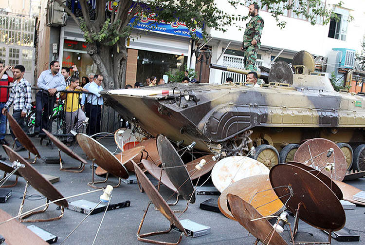 An image from the state-run news agency ISNA shows Iranian soldiers using tanks to destroy satellite dishes in 2013. Iran jams satellite signals to prevent citizens from accessing Western news and entertainment channels. (AFP/ISNA/Mohsen Tavaro)