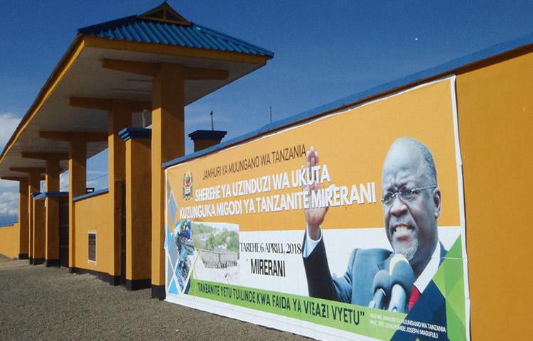 A banner of Tanzanian President John Magufuli adorns a wall around the country's tanzanite mines. Magufuli's government has imposed a series of restrictions on rights, including freedom of expression. (AFP/Joseph Lyimo)