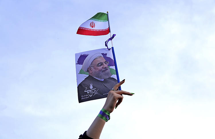 A supporter of Iranian President Hassan Rouhani waves a poster with his image at an election rally in Tehran in May 2017. Rouhani’s campaign promises include calls for greater press freedom and access to information. (AP/Ebrahim Noroozi)
