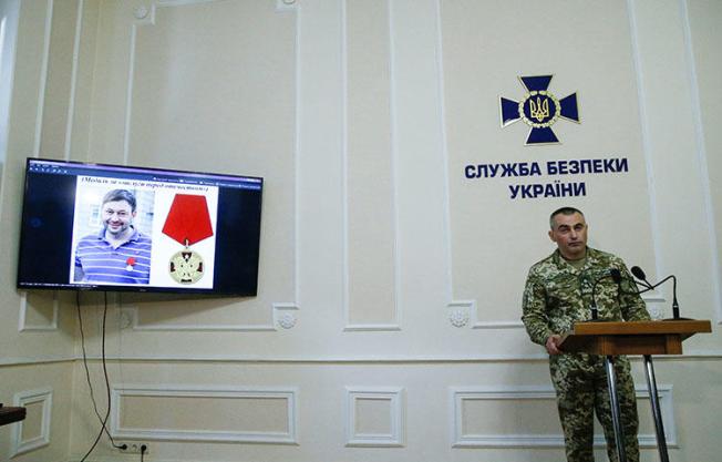 A portrait of the director of RIA Novosti-Ukraine's Kiev office director, Kirill Vyshynsky, on a monitor during a news briefing at the headquarter of the Ukrainian State Security Service in Kiev, Ukraine on May 15, 2018. On May 15, 2018, Ukrainian state security agents searched RIA Novosti-Ukraine's Kiev office and detained Vyshynsky, accusing the agency of being used in an