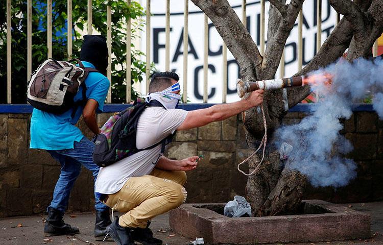 Un manifestante dispara un mortero casero contra la policía antimotines durante una protesta contra el gobierno del presidente Daniel Ortega en Managua, Nicaragua, el 28 de mayo de 2018. Civiles atacaron e incendiaron una radioemisora progubernamental en Managua el 28 de mayo. (Oswaldo Rivas / Reuters)